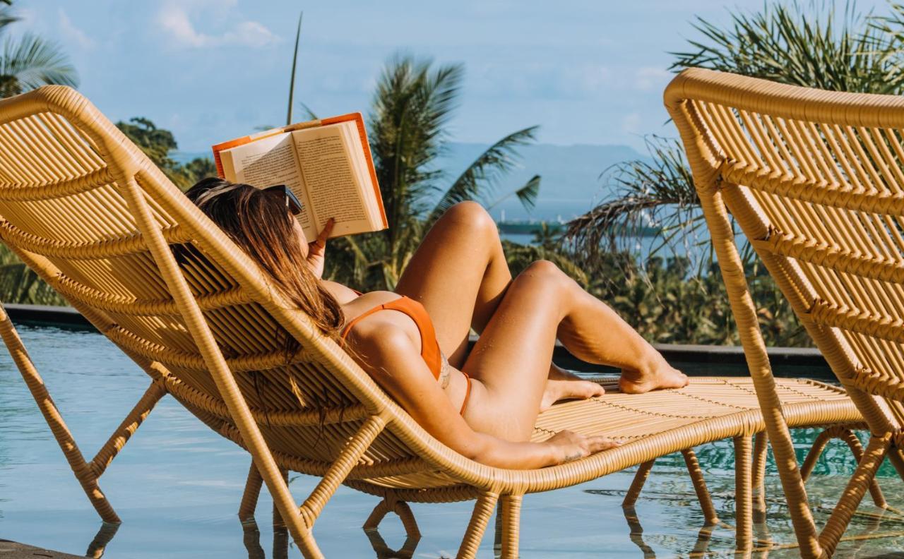 Neano Escape Manggis Exterior foto A woman reading a book on a beach